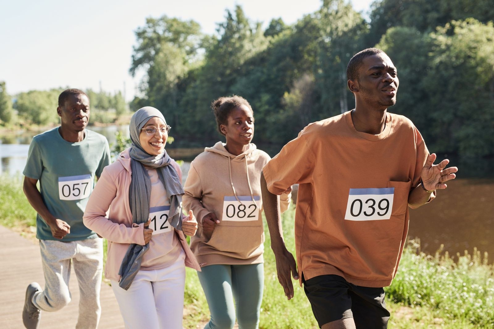 Des participants portant un dossard prennent part à une course dans un parc.