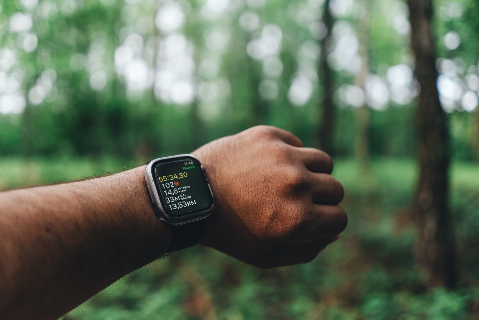 Une montre affiche des données de course devant un bois.