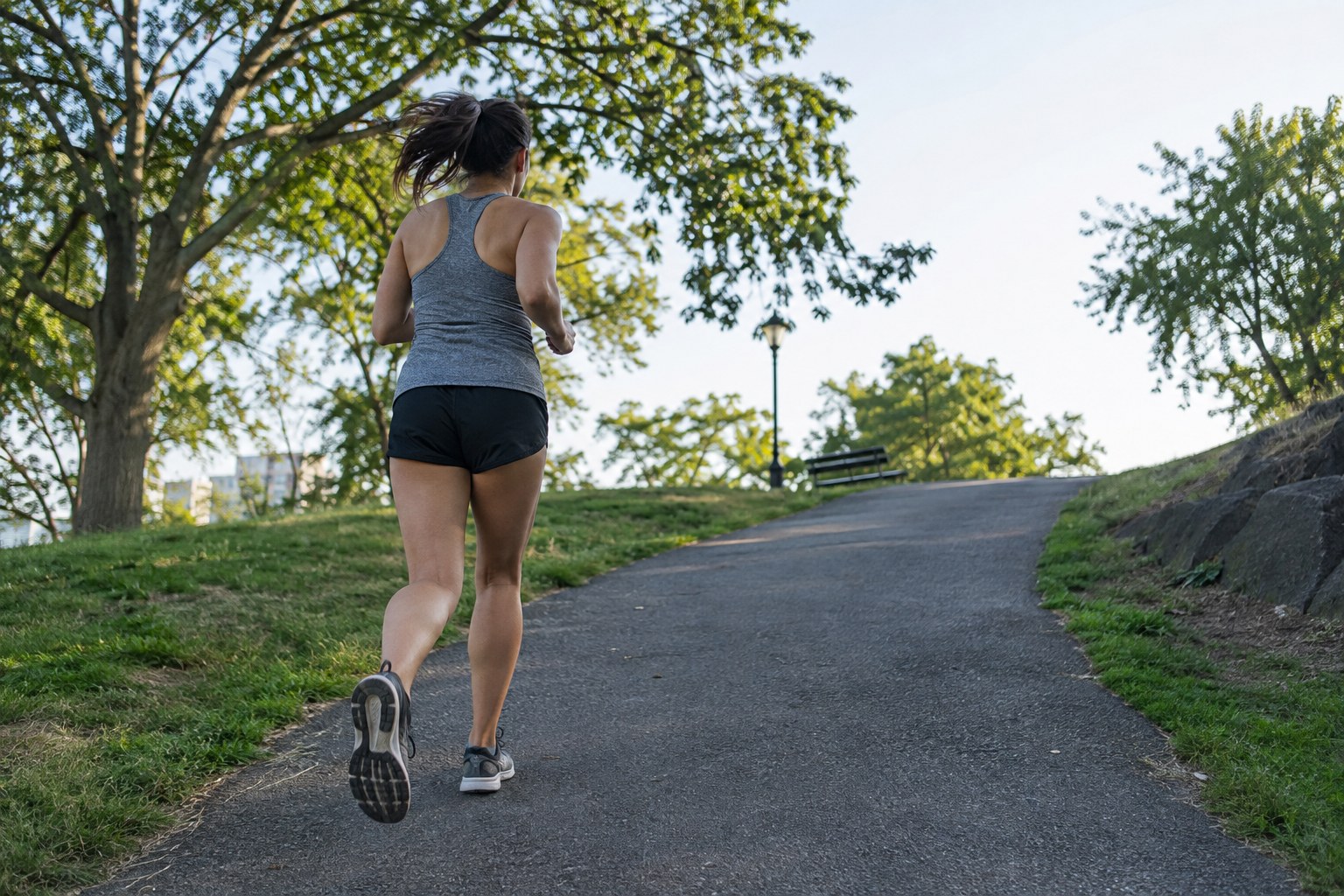 Un coureur approche une petite pente dans un parc.