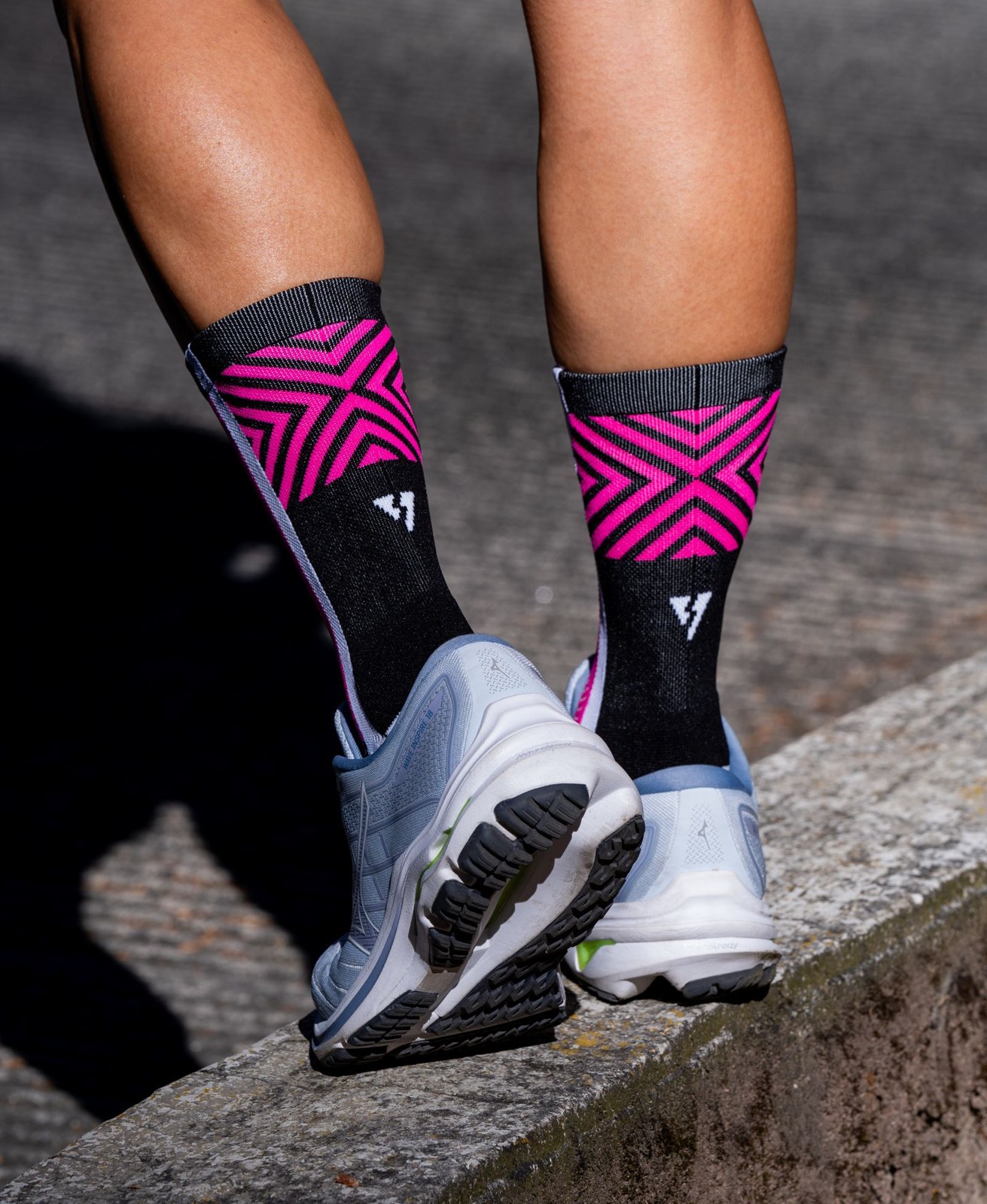 Gros plan sur des chaussettes de sport à motifs et des chaussures de course.