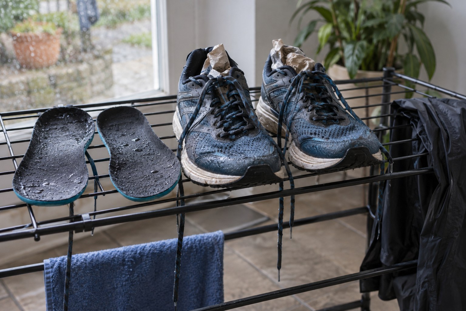 Des chaussures sèchent sur une grille avec les semelles intérieures retirées.