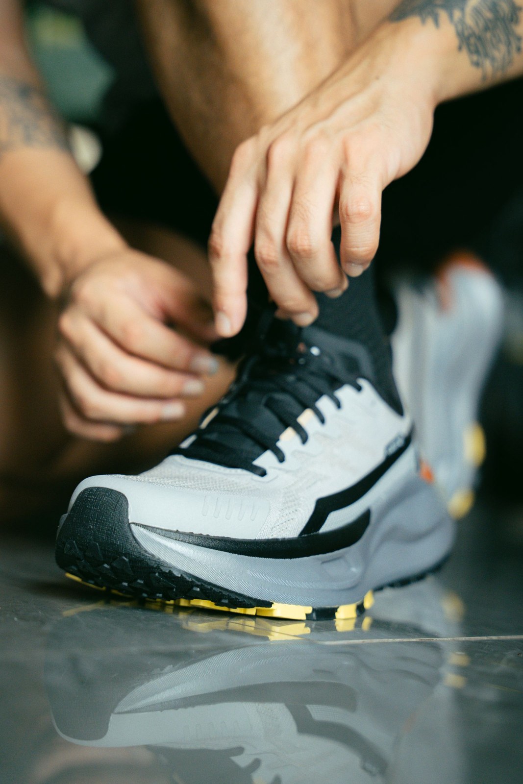 Des mains ajustent les lacets d’une chaussure de course avant utilisation.