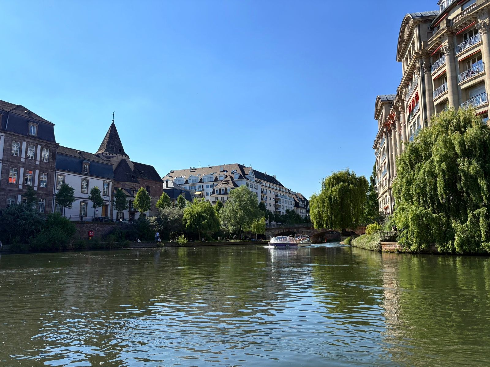 Des bâtiments et des arbres bordent une voie d’eau à Strasbourg.